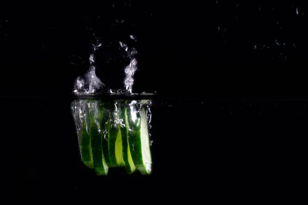 Dilimlenmiş Salatalık Arka Planda Karanlık Bir Yiyecek Sebze Konseptiyle Suyun — Stok fotoğraf