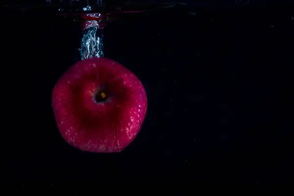 Kırmızı Elma Arka Planda Karanlık Bir Gıda Konseptinde Suyun Altında — Stok fotoğraf