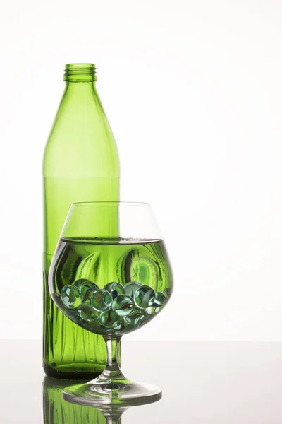 Leuchtend Grüne Muster Einem Glas Mit Flüssigen Und Dekorativen Kugeln — Stockfoto
