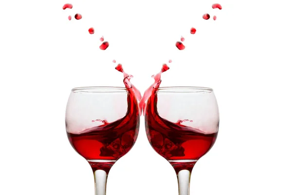 the same and bright splashes of red wine in mirrored glasses on a white background the concept of alcohol objects for design