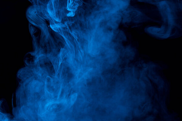Mystical charming patterns formed by a cloud of blue cigarette vapor on a dark background