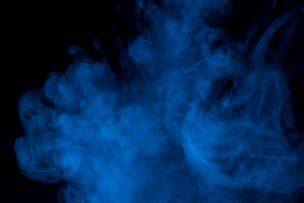 Thick cloud of blue cigarette vapor against a dark background fascinating abstraction background for design