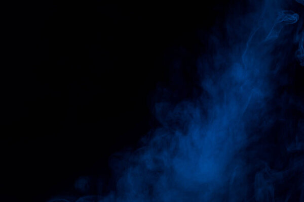 Thick and mysterious blue cigarette vapor on a dark background bewitching abstraction background for design