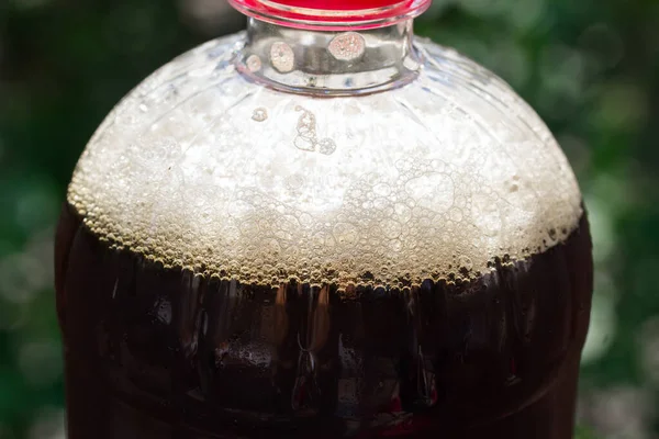 Alkollü içeceklerin yeşil yeşillik kavramının bulanık arka planında köpüklü ve köpüklü koyu bira.