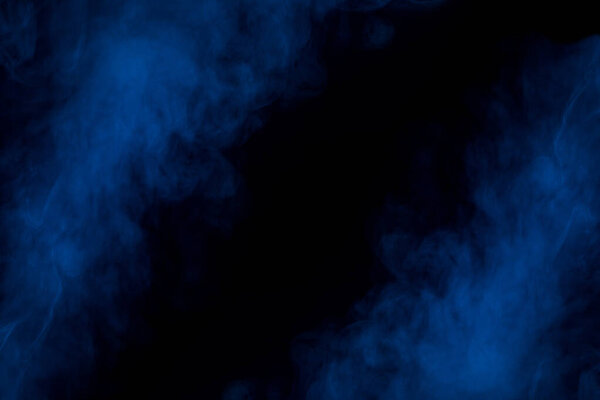 Two blue clouds of cigarette vapor thick and mysterious on a dark background