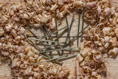 Kalbin etrafındaki işyerinde gümüş ve ince metal çiviler ince yuvarlak çiplerle kaplıdır. Doğrama ve marangozluk kavramı.