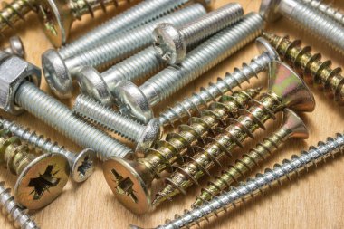 Parlak cıvatalar ve vidalar ahşap arka planda yakın çekim araçlar ve onarım kavramı