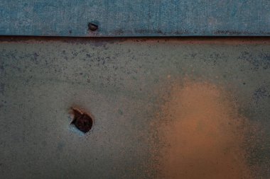 Metal yüzeyin parlak sanatsal dokusu, vidası ve parlak turuncu boya arkaplanı olan bir delik tasarım için.