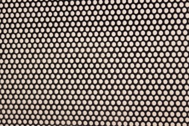 Tasarım için küçük yuvarlak delikleri olan koyu plastiğin parlak dokusu