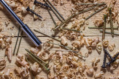 Çivi çivileri ve metal bir tornavida, ahşap kalasların iş yerinde ince çiplerle kaplıdır. Doğrama ve marangozluk kavramı.