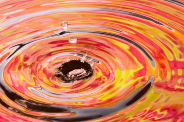 Çok renkli yaprakların yansıtıldığı suyun yüzeyine parlak bir sonbahar sıçraması.