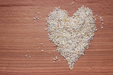 Kalp, tahtanın üzerinde arpa gevreğiyle kaplıydı. Sağlıklı beslenme ve vejetaryenlik kavramı.