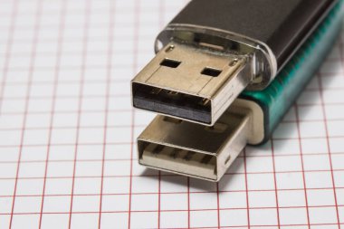 İki farklı flaş bellek bir kağıt parçasına yakın duruyor. İş ve bilgi kavramı.