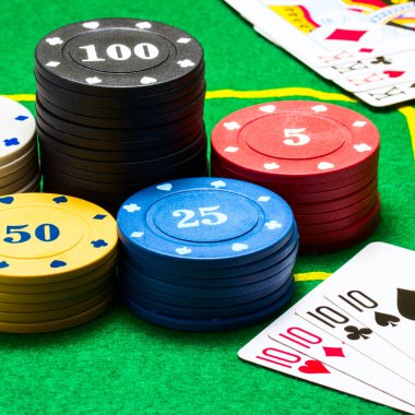 Oyun kartları ve poker çiplerinin yeşil tuval konsepti ve kumarhane üzerindeki parlak kolonların kombinasyonları