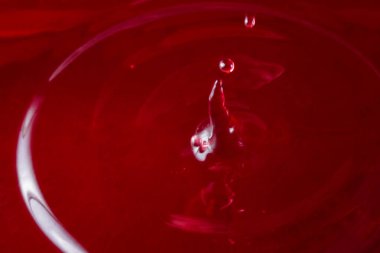 Düşen bir damla kırmızı şarap üzümlerden yapılan tatlı bir alkollü içeceğin parlak bir damlası.
