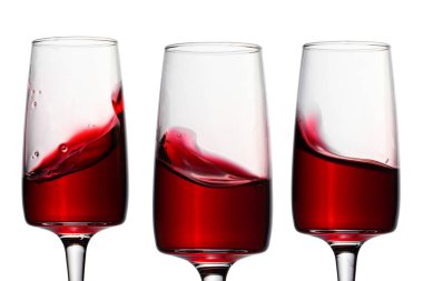 Kırmızı şarap ve parlak nesneleri beyaz arka plan alkol kavramına göre tasarlamak için üç zarif bardak.