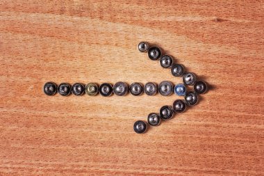 Ucu gümüşi küçük vidalar ile kaplı metal ok ahşap arka plan kavramı araçlar ve endüstri