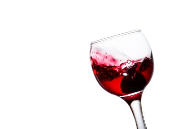 İştah açıcı kırmızı şarap bir bardağa sıçrıyor altında üzüm ve tatlı bir alkolik içeceği var.