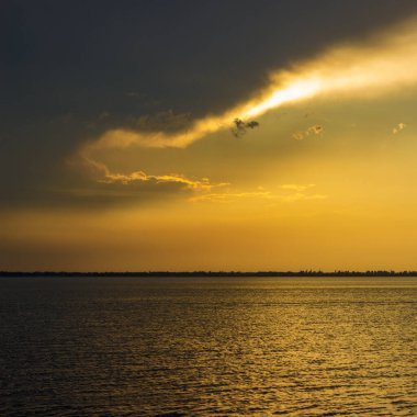 Büyülü günbatımı, haliçlerindeki güzel gökyüzünün üzerinde. Suyun yüzeyindeki hiç kimse sıcak bir parıltıyı yansıtmıyor.