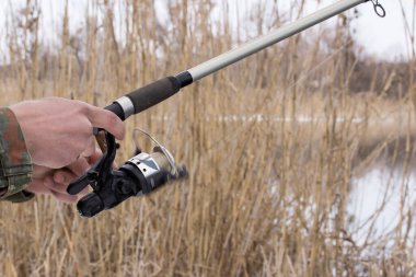 Balıkçının elinde dönen bir makara var. Balıkçılık konsepti.