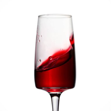 Beyaz arka planda ince bir bacakta, yüksek bardakta kırmızı şarap dalgası. Üzümlerden yapılmış muhteşem bir alkollü içecek.
