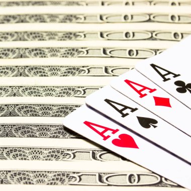 Kumarhanelerin ve kumarhanelerin başarısı ve kazanılması konsepti dolar banknotlarının üzerinde dört as yatar.