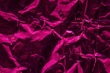 Kırmızı güzel folyonun parlak kırmızı dokusu. Tasarım için buruşuk pürüzsüz bir yüzey arkaplanı var.