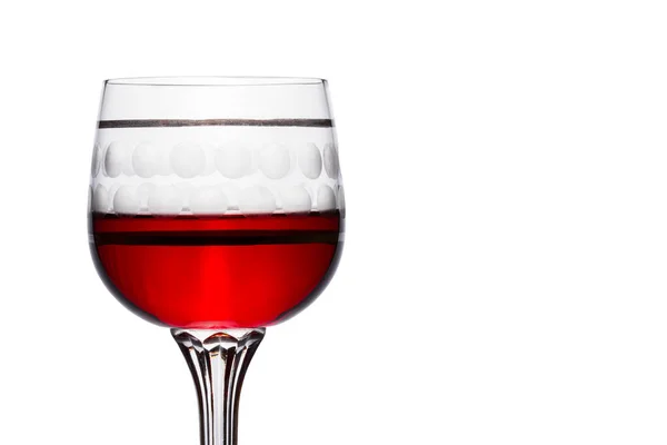 白を基調とした脚の高いヴィンテージグラスに鮮やかな赤ワインブドウから作られたおいしいアルコール飲料 — ストック写真