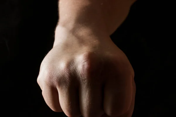 Karanlık bir arka plan kavramı olan grev ve özgüven agresif bir jest için yumruğunu sıkıca kavrıyor.