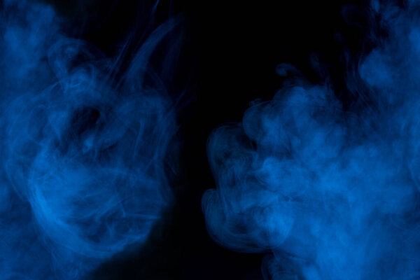 Thick and blue cigarette vapor on a dark background mysterious atmosphere mystical abstraction for design concept of smoking
