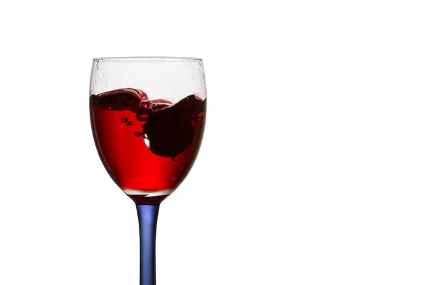 白を基調とした赤ワインのブドウのグラスに落ちアルコール飲料の明るいスプラッシュ — ストック写真