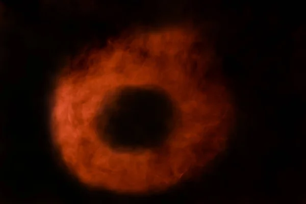 Der Orangefarbene Ring Aus Zigarettendampf Auf Schwarzem Hintergrund Sieht Aus — Stockfoto