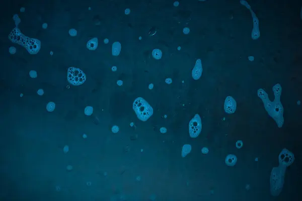 Krople Detergentu Ciemnoniebieskim Szklanym Tle Projektowania Tajemniczej Abstrakcji — Zdjęcie stockowe