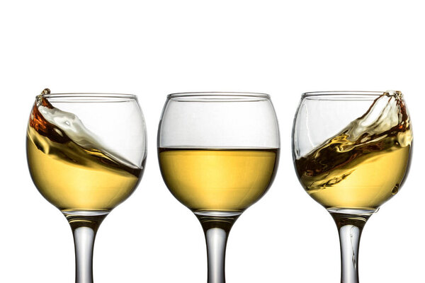 three glasses with white wine and various charming bursts of objects for the design of the concept of alcohol