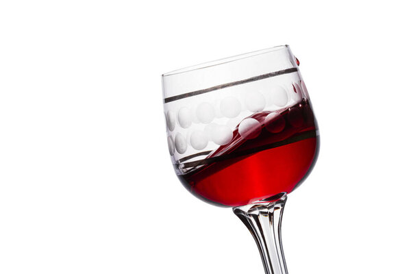 exciting surface of red wine in a glass like a small wave on a white background appetizing alcoholic drink made from grapes