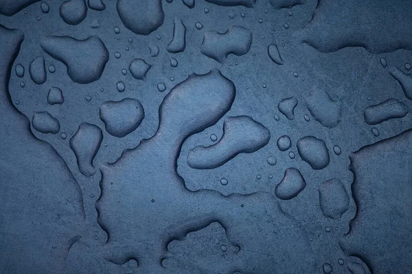 Mavi metal bir tabaka üzerindeki parlak mavi su damlası dokusu tasarım için heyecan verici soyut arkaplanı kapat