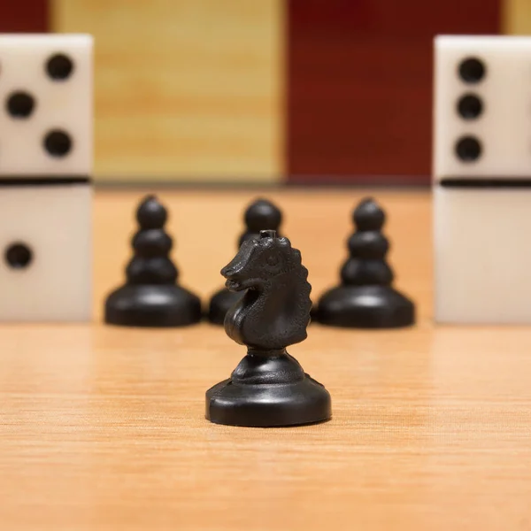 Черный Шахматный Рыцарь Фоне Пешек Домино Концепция Настольных Игр Крупным — стоковое фото