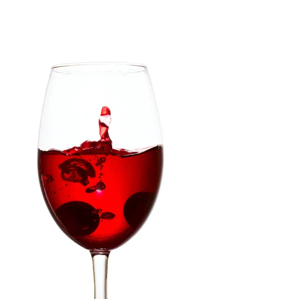 赤ワインと口に水を注ぐアルコール飲料のスプラッシュを形成したブドウのガラスに落ちた — ストック写真