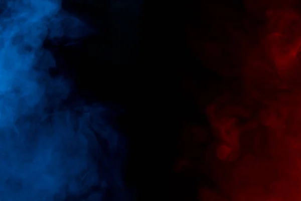 Karanlık bir arka plandaki mavi ve kırmızı sigara dumanı Cadılar Bayramı için gizemli bir kavram olan mistik bir gece sisi soyutlaması gibidir.