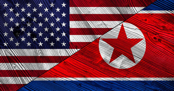 Flags of United States of America and North Korea on wooden planks