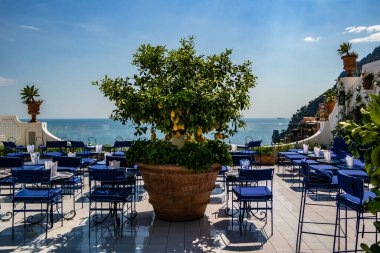 View on a terrace with blue chairs and lemon trees in Positano, Campania - Italy