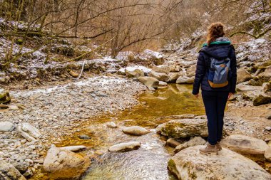 Sırt çantalı genç bir kadın dağda yürüyüş yapıyor.