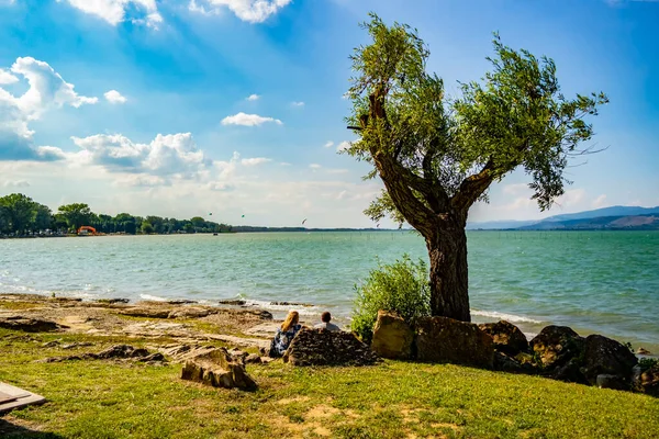 Oturanlar Trasimeno Gölü, Umbria - İtalya 'nın güzelliğine hayran.