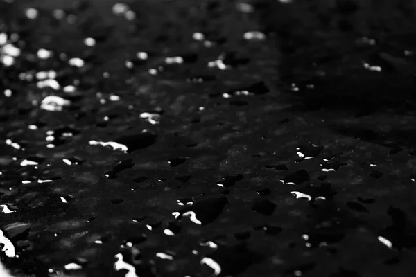 Rain drops on a black surface
