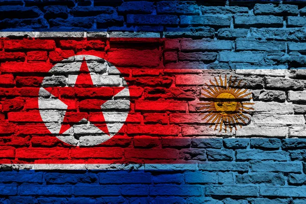 Flags of North Korea and Argentina on the brick wall