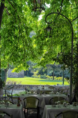 Ağaçların altında yemek masaları