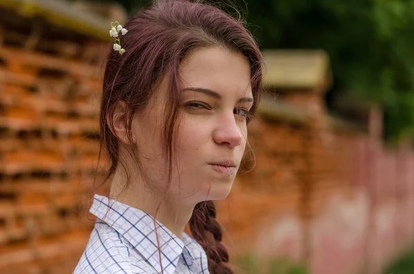 kırmızı tuğla duvar arka plan üzerinde oldukça şüphelenen kız