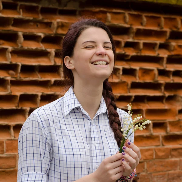 kırmızı tuğla duvar arka plan üzerinde oldukça gülümseyen kız