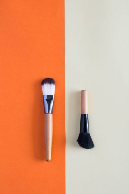 Renkli arka planlarda makyaj fırçası ve kozmetik