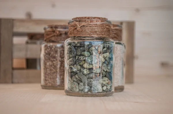 Small glass jars with sand and stones from the beach — Stock Photo, Image